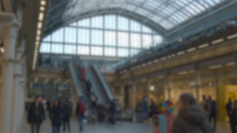 Toma-Desenfocada-De-Escaleras-Mecánicas-Y-Vestíbulo-En-La-Estación-De-Tren-De-St-Pancras-En-Londres,-Reino-Unido-Con-Viajeros