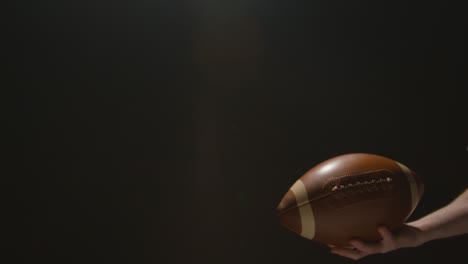 Close-Up-Studio-Shot-Of-American-Football-Player-Throwing-And-Catching-Ball-1