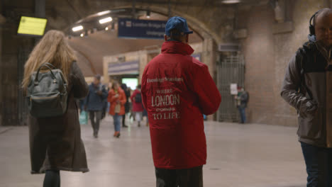 Concurrida-Entrada-A-La-Estación-De-Tren-Del-Puente-De-Londres,-Londres,-Reino-Unido-Con-El-Hombre-Distribuyendo-Periódicos-Gratuitos