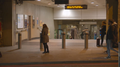 Autobús-Con-Pasajeros-Fuera-De-La-Estación-De-Tren-Del-Puente-De-Londres-Por-La-Noche