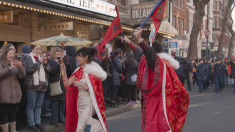 Menschen-Mit-Sonnenschirmen-Und-Fahnen-In-Einer-Parade-Um-Den-Trafalgar-Square-In-London-Uk-Im-Jahr-2023,-Um-Das-Chinesische-Neujahr-Zu-Feiern