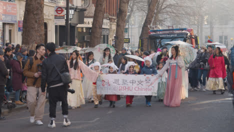 Kinder,-Die-2023-Ein-Banner-In-Der-Parade-Um-Den-Trafalgar-Square-In-London-Tragen,-Um-Das-Chinesische-Neujahr-Zu-Feiern