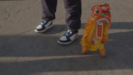 Nahaufnahme-Eines-Kindes-Mit-Löwentanz-Marionetten-Souvenir-Von-Marktständen-Rund-Um-Den-Trafalgar-Square,-Das-Das-Chinesische-Neujahr-2023-Feiert