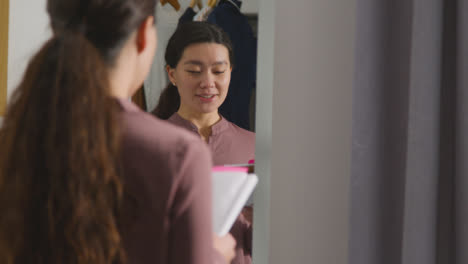 Young-Woman-In-Home-Practising-Job-Interview-Technique-Reflected-In-Mirror-1