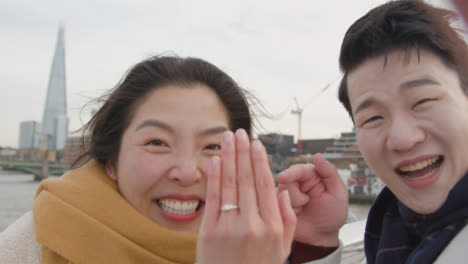 Young-Asian-Couple-In-London-UK-Making-Video-Call-Home-On-Phone-Announce-Engagement-To-Family