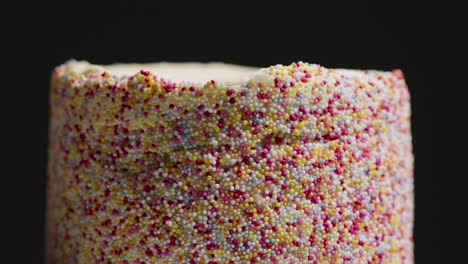 Close-Up-Studio-Shot-Of-Revolving-Birthday-Cake-Covered-With-Hundreds-And-Thousands-Decorations-6