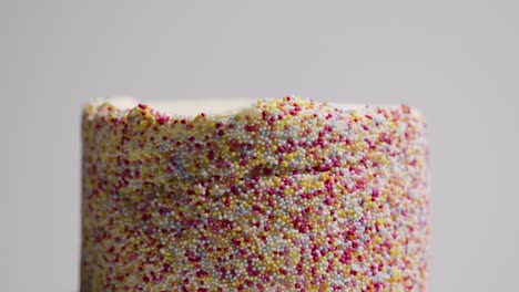Close-Up-Studio-Shot-Of-Revolving-Birthday-Cake-Covered-With-Hundreds-And-Thousands-Decorations-11