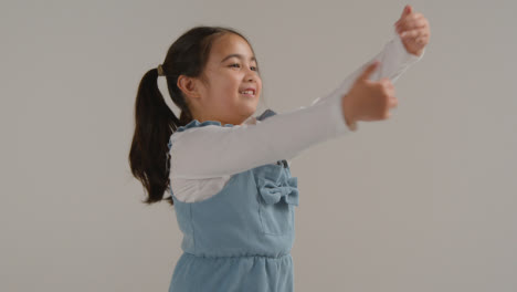 Studio-Portrait-Of-Hyperactive-Girl-Jumping-Against-White-Background