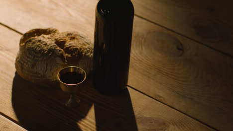Religious-Concept-Shot-With-Chalice-Bread-And-Wine-On-Wooden-Table-With-Pool-Of-Light-2