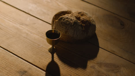 Religious-Concept-Shot-With-Chalice-Bread-And-Wine-On-Wooden-Table-With-Pool-Of-Light-6