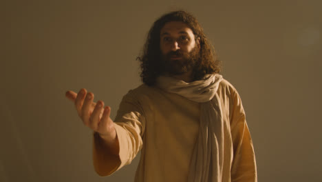 Mann-In-Gewändern-Mit-Langen-Haaren-Und-Bart,-Der-Die-Figur-Von-Jesus-Christus-Darstellt,-Der-Predigt-Oder-Betet