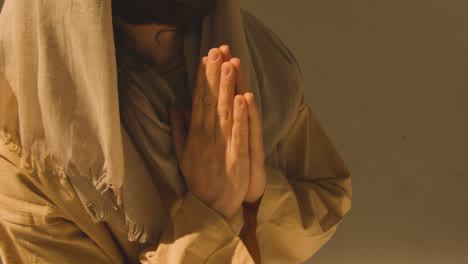 Close-Up-Shot-Of-Man-Wearing-Robes-With-Long-Hair-And-Beard-Representing-Figure-Of-Jesus-Christ-Praying-1