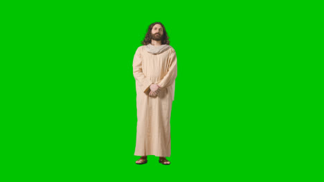 Studioaufnahme-Eines-Mannes-In-Roben-Und-Sandalen-Mit-Langen-Haaren-Und-Bart,-Der-Die-Figur-Jesu-Christi-Auf-Grünem-Bildschirm-Darstellt
