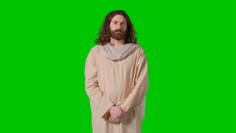 Porträtaufnahme-Eines-Mannes-In-Roben-Mit-Langen-Haaren-Und-Bart,-Der-Die-Figur-Jesu-Christi-Auf-Grünem-Bildschirm-Darstellt