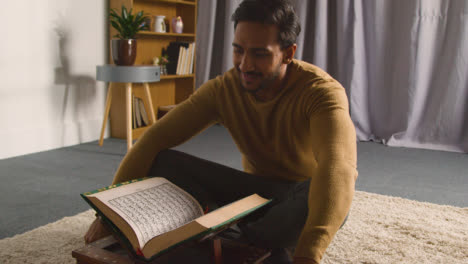 Muslimischer-Mann-Sitzt-Zu-Hause-Auf-Dem-Boden-Und-Rezitiert-Aus-Dem-Koran