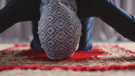 Muslimische-Frau-Trägt-Hijab-Zu-Hause,-Kniet-Auf-Einer-Gebetsmatte-Und-Betet-4