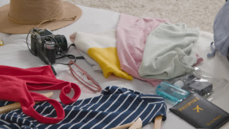 Close-Up-Of-Open-Suitcase-On-Bed-At-Home-Being-Packed-For-Summer-Holiday-