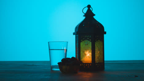 Tracking-Shot-of-Lantern-Water-and-Dates-On-a-Table-During-Dusk-Ramadan-Celebrations