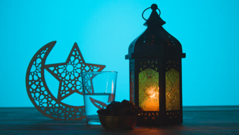 Tracking-Shot-of-a-Lantern-Water-and-Dates-On-Table-During-Dusk-Ramadan-Celebrations