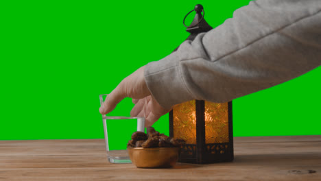 A-Tracking-Shot-of-Lantern-Water-and-Dates-In-Front-of-a-Green-Screen