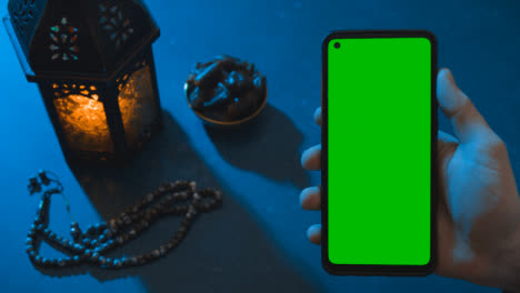 Wide-Shot-of-Lantern-Water-and-Dates-with-a-Green-Screen-Phone-at-Dusk