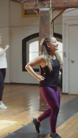 Vertical-shot-of-dance-teacher-learning-movements-with-group