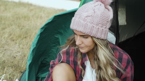 Pensive-camping-girl-wearing-woolen-hat