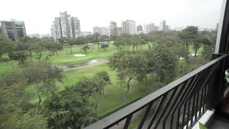 Dolly-Shot-De-La-Hermosa-Vista-De-Un-Campo-De-Golf-Visto-Desde-Un-Balcón-En-Un-Edificio-Cercano