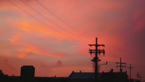 Powerline-silhouette-against-pink-sky,-static-shot