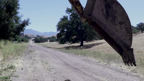 Backhoe-tractor-digging-up-a-leaking-water-line-on-a-hot-day