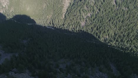 Aerial-of-canyon-camera-pointed-down-over-the-top-of-the-high-cliffs-and-flying-over-them-to-reveal-rest-of-the-canyon