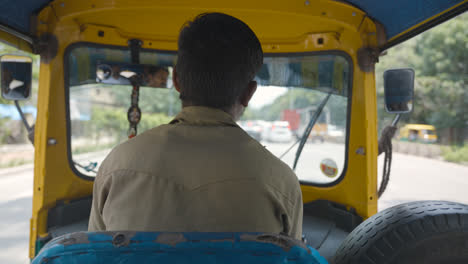 Passenger-View-Of-Man-Driving-Auto-Rickshaw-Taxi-Along-Street-In-Bangalore-India