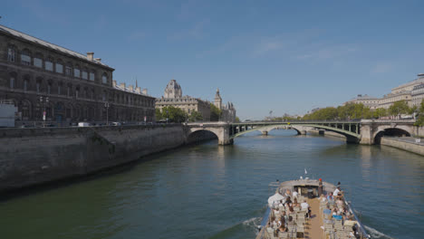 Barco-Turístico-Pasando-Por-Debajo-Del-Puente-Pont-Notre-Dame-Cruzando-El-Río-Sena-En-París,-Francia,-Con-Turistas-Y-Tráfico-1