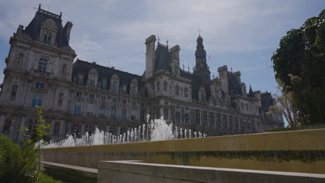 Exterior-Of-Hotel-De-Ville-In-Paris-France-With-Fountains-In-Foreground-In-Slow-Motion