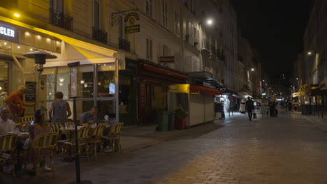 Tiendas,-Cafés-Y-Restaurantes-En-La-Zona-De-La-Rue-Cler-En-París,-Francia-Por-La-Noche