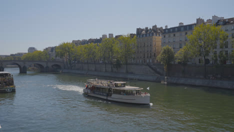 Tourist-Boat-Going-Under-Bridge-In-Quais-De-Seine-Area-Of-Paris-France
