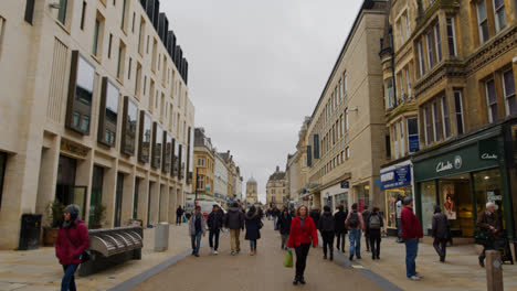 Vista-A-Lo-Largo-De-Cornmarket-Street-En-El-Centro-De-La-Ciudad-De-Oxford-Con-Tiendas-Y-Peatones