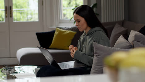 Besorgte-Frau,-Die-Drinnen-Auf-Dem-Sofa-Sitzt-Und-Von-Zu-Hause-Aus-Mit-Einem-Laptop-Arbeitet,-Macht-Sich-Sorgen-über-Die-Lebenshaltungskostenkrise-3