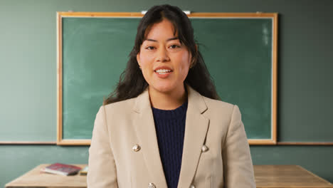 Close-Up-Shot-Of-Female-Teacher-In-Classroom-Standing-In-Front-Of-Board-Teaching-Lesson