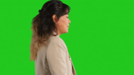 Close-Up-Studio-Profile-Shot-Of-Female-Teacher-Or-Businesswoman-Walking-Past-Green-Screen