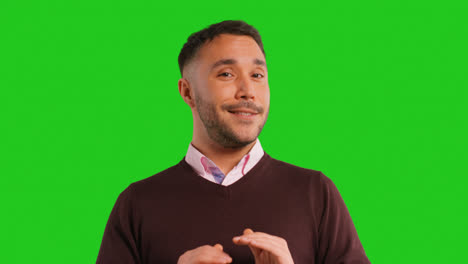 Close-Up-Studio-Portrait-Of-Mature-Male-Teacher-Talking-To-Class-Standing-Against-Green-Screen-Background-4