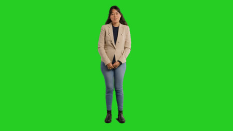 Full-Length-Studio-Portrait-Of-Female-Teacher-Talking-To-Class-Standing-Against-Green-Screen