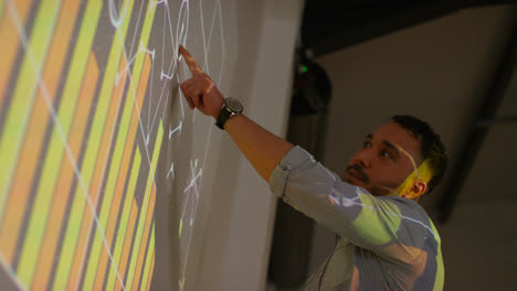 Close-Up-Of-Male-Teacher-Giving-Maths-Or-Science-Lesson-In-School-Standing-At-The-Front-Of-Class-With-Projection-Of-Graph