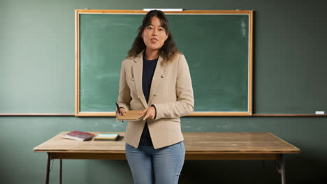 Lehrerin-Im-Klassenzimmer-Steht-Vor-Der-Tafel-Und-Unterrichtet