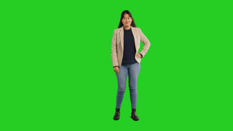 Full-Length-Studio-Portrait-Of-Female-Teacher-Or-Businesswoman-Standing-Against-Green-Screen-With-Hand-On-Hip