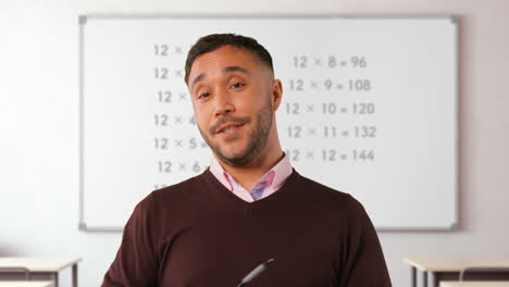 Close-Up-Shot-Of-Mature-Male-Teacher-In-Classroom-Standing-In-Front-Of-Board-Teaching-Elementary-Maths-Lesson