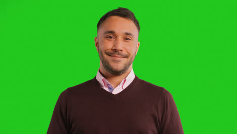 Close-Up-Studio-Portrait-Of-Male-Teacher-Or-Businessman-Standing-Against-Green-Screen-Smiling