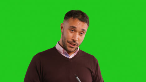 Close-Up-Studio-Portrait-Of-Mature-Male-Teacher-Talking-To-Class-Standing-Against-Green-Screen-Background-2