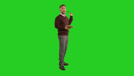 Full-Length-Studio-Portrait-Of-Mature-Male-Teacher-With-Notebook-Talking-To-Class-Standing-Against-Green-Screen-3