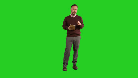 Full-Length-Studio-Portrait-Of-Mature-Male-Teacher-With-Notebook-Talking-To-Class-Standing-Against-Green-Screen-2